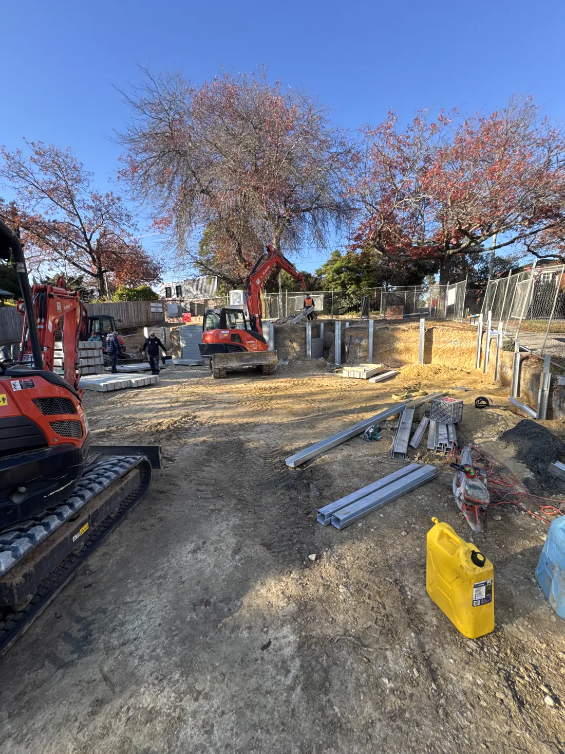 Retaining wall build in progress with excavator