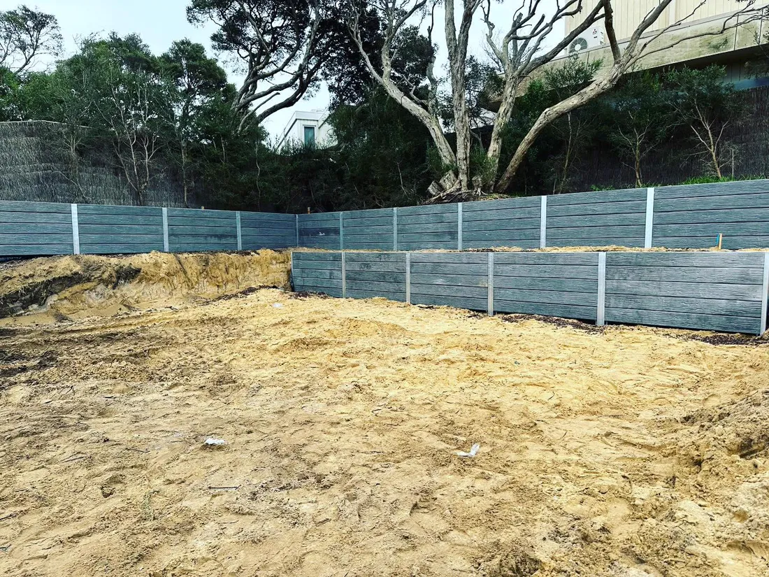 Engineered sleeper retaining walls around a large building cut