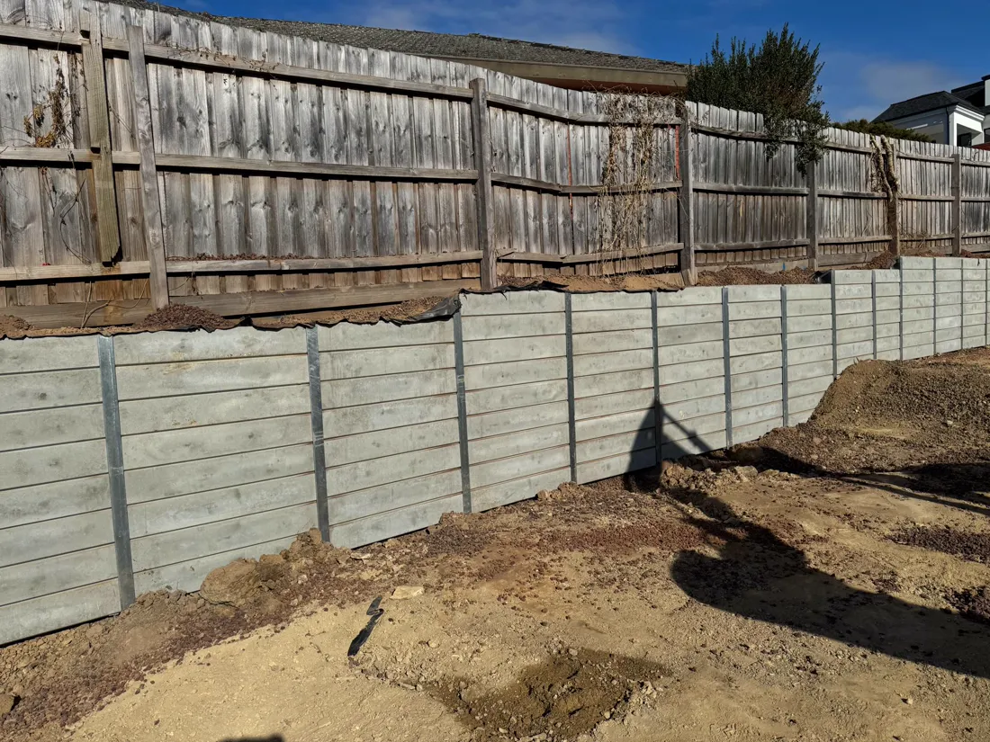 Tiered grey sleeper retaining walls on a residential build